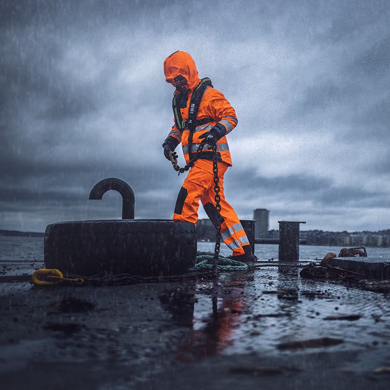 High-visibility rainwear used during marine work on a wet vessel deck in rough weather—designed to deliver maximum protection, grip and visibility in harsh, stormy conditions.