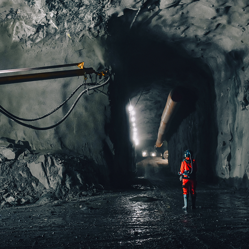 High-visibility rainwear worn by a worker inside a wet underground tunnel, illuminated by work lights—engineered to protect against moisture, low light and extreme working conditions.